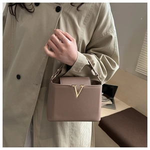 Dettaglio della borsa in pelle taupe con elegante fibbia metallica dorata a forma di V