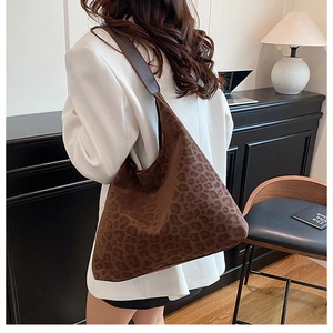 Modern brown leopard print large capacity hobo bag worn over shoulder by a model