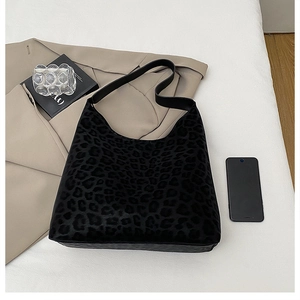 Macro detail of the leopard print pattern and premium texture on black hobo shoulder bag