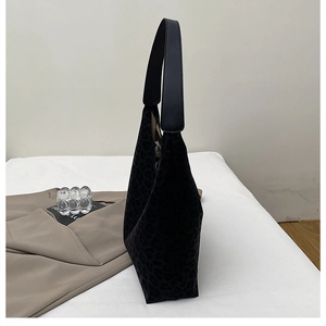 Detail shot of black leopard print suede tote with elegant leather strap and soft silhouette