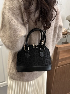 Vintage leopard shell handbag with gold hardware shown in a stylish lifestyle setting