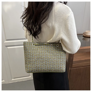 Detail van meerkleurige tweed shopper met goudkleurige kettingriem en metalen ringgreep