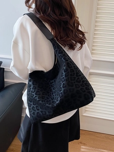 Large black leopard print hobo shoulder bag for women shown in a lifestyle model setting