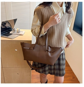 Close-up of brown vintage matte leather tote bag with decorative straps for commute