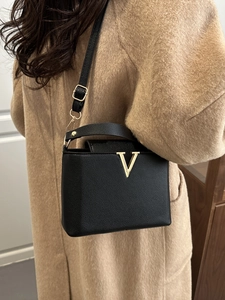 Sac à main élégant en cuir noir avec garniture dorée en V et bandoulière réglable