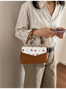 Detail of a chic shoulder bag with heart bear print and unique knotted handle design