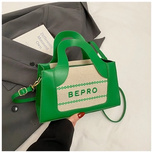 Detail von grünem PU-Leder und Canvas-Kontrast mit BEPRO-Stickerei auf der Handtasche
