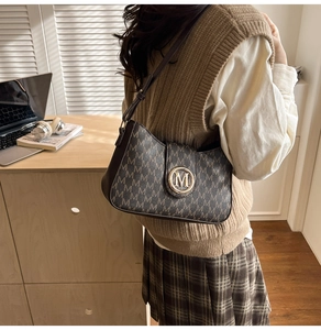 Close-up of retro letter print hobo bag with vintage leather texture and gold logo buckle
