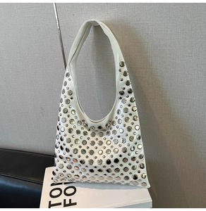 Detail of white leather hobo bag with silver metallic dot rivets and sleek single strap