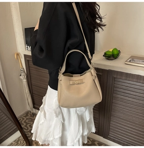Chic apricot bucket bag with lychee texture pattern and elegant gold buckle detail