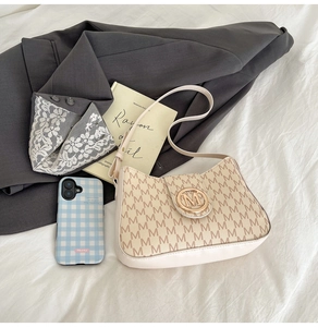 Détail de l'imprimé monogramme sur sac en cuir crème avec boucle en métal doré chic