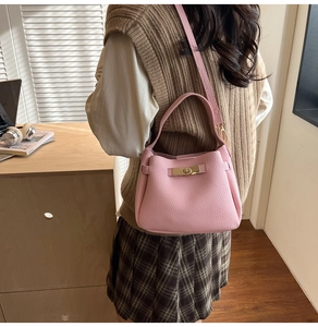 Sac seau en cuir rose à grain litchi avec boucle porté par un mannequin femme
