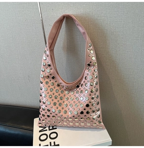Detailed close-up of pink shoulder bag featuring decorative silver metal rivets and studs