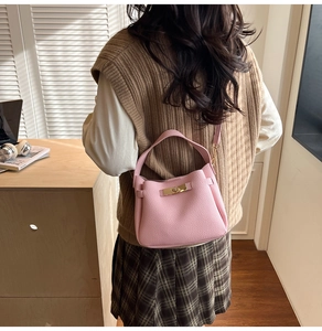 Détail du sac à main en cuir litchi rose avec fermoir rotatif doré élégant et texture