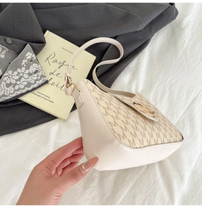 Gros plan d'un sac porté épaule rétro avec imprimé lettre M et boucle en métal doré