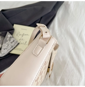 Détail de la toile monogramme et de la bandoulière en cuir réglable avec boucles dorées