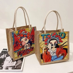 Detail of jute tote bags with trendy oriental print and woven rope handles on magazines