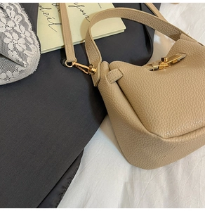 Gros plan du sac à main beige en cuir grainé avec boucle dorée et bandoulière