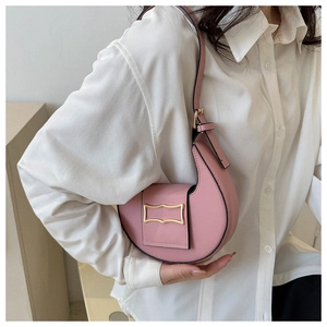 Close-up of pink crescent shoulder bag featuring premium texture and gold metal hardware