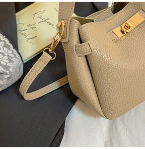 Détail du sac à main en cuir grainé avec fermoir doré et texture de couture précise