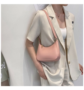 Minimalist light pink baguette shoulder bag for women styled with a beige suit