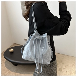 Close-up of light blue bucket bag featuring unique cracked ice texture and drawstring closure