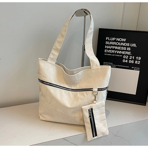 Minimalist cream tote bag set with a small detachable pouch and textured surface