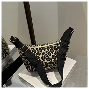 Close-up of leopard print canvas crescent bag with black strap and gold metal hardware