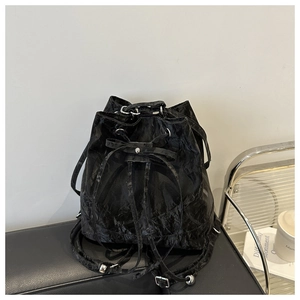 Close-up of black pleated fabric texture and bow detail on stylish bucket bag