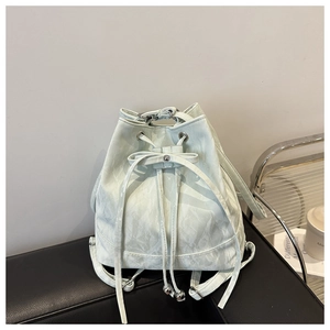 Detail of mint green drawstring bucket bag with pleated texture and bow decoration