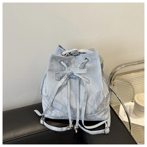 Close-up of light blue bucket bag showing water ripple texture and drawstring detail