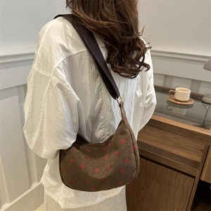 Brown corduroy hobo bag with red strawberry pattern and wide fabric shoulder strap