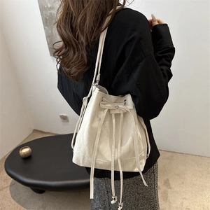 White drawstring bucket bag with silver bead hardware and soft PU leather texture