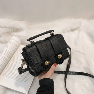 Close-up of black crocodile pattern PU leather crossbody bag with gold twist locks