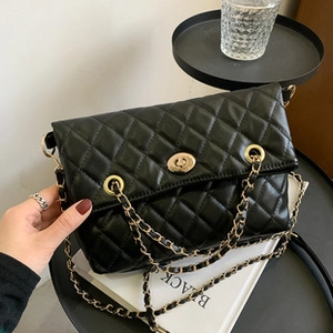 Detailed view of black quilted PU leather crossbody bag with golden chain and clasp