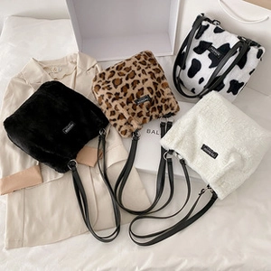 Detail view of plush crossbody bags in black, white, leopard, and cow print patterns