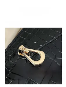 Close-up of black crocodile texture leather with elegant gold fan-shaped metal buckle lock