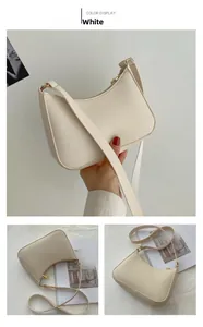 Detailed view of a white minimalist half-moon hobo bag with smooth leather and gold zipper