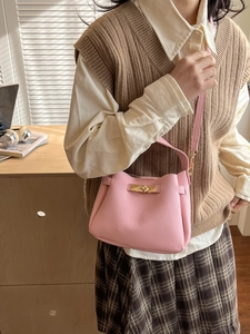 Sac à main rose en cuir grainé avec fermoir doré tournant et bandoulière réglable