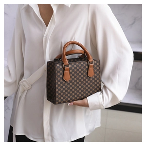 Detail of vintage retro crossbody bag with geometric pattern and brown handle