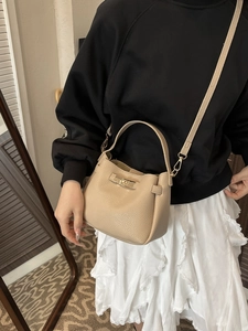 Sac seau élégant en cuir beige grainé avec poignée et fermoir tournant doré