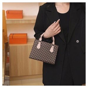 Close-up of vintage monogram mini tote bag with leather handles shown on a model