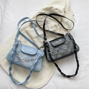 Détail de sacs bandoulière tendance avec texture denim, chaînes fleurs et doubles sangles