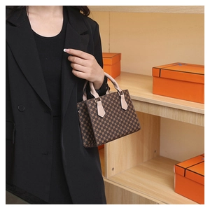 Detail of vintage plaid mini tote bag with brown geometric patterns and leather handles
