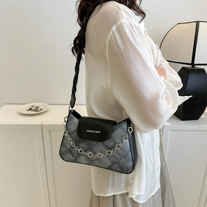 Détail du sac bandoulière à carreaux gris avec sangle tissée noire et chaîne florale