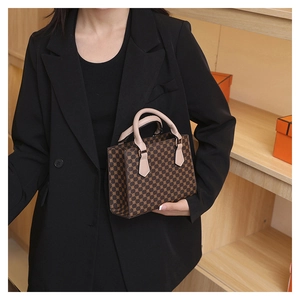 Close-up of vintage brown plaid pattern handbag with stylish beige leather handle detail