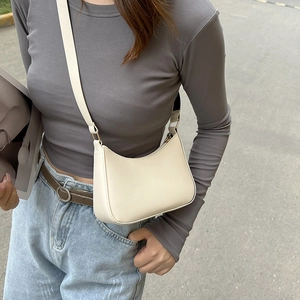 Dettaglio della borsa a mezzaluna color crema in pelle PU con fibbia in metallo dorato