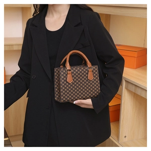 Close-up of vintage brown plaid handbag with dual handles and metal buckle hardware