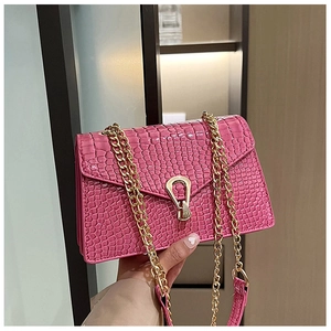 Detail of bright pink crocodile pattern bag with golden U-shaped lock and chain strap
