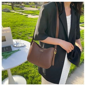 Borsa a tracolla in pelle marrone a forma di mezzaluna con cuciture e logo dorato